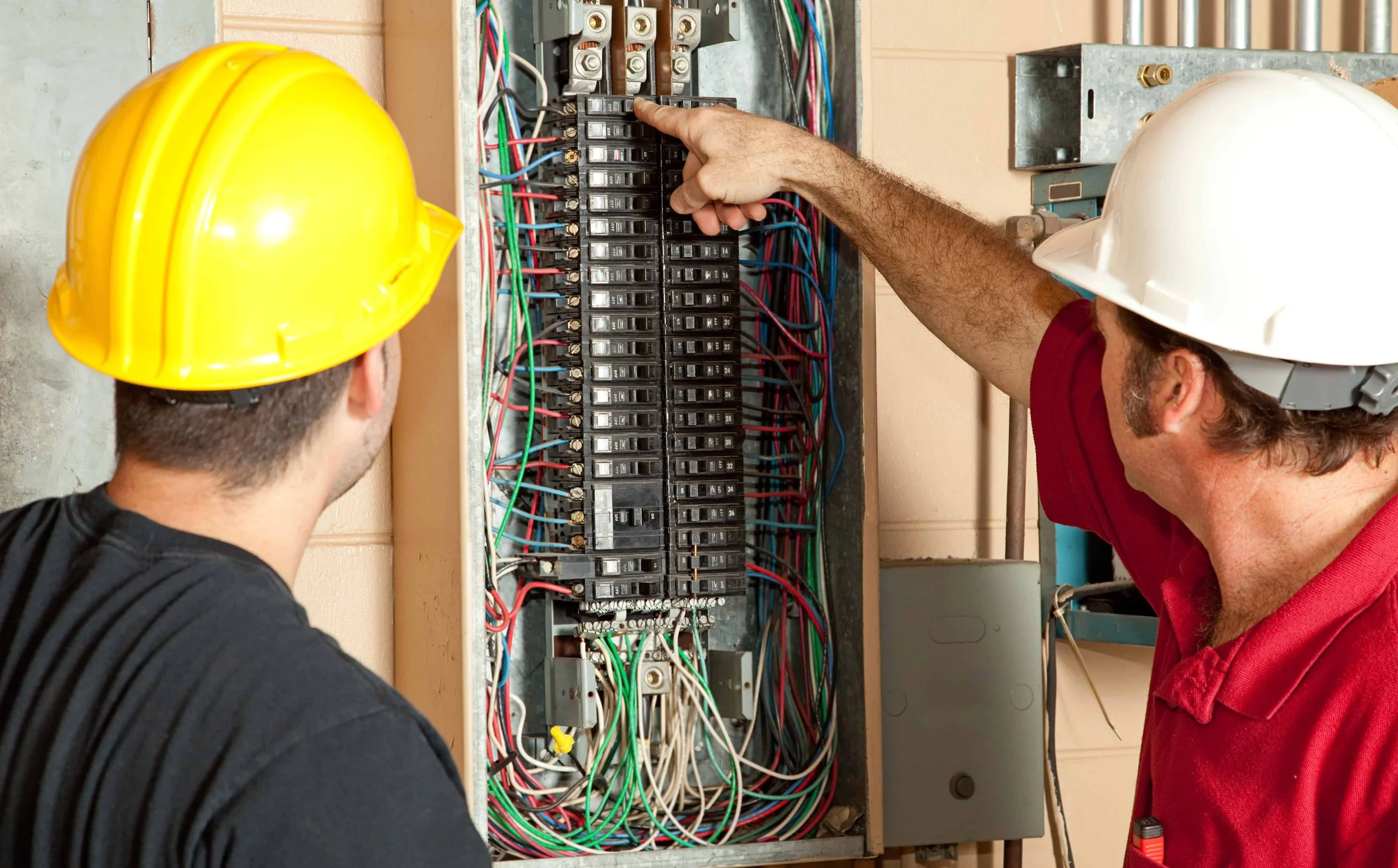 Electricians inspecting an electrical panel
